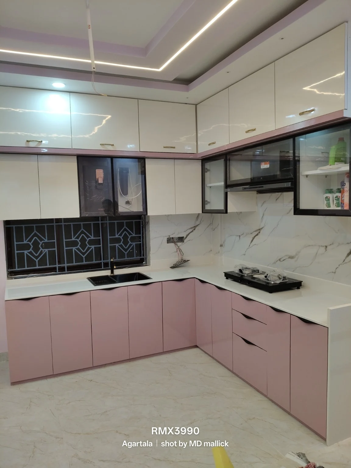 Pink-toned L-shaped kitchen with marble backsplash